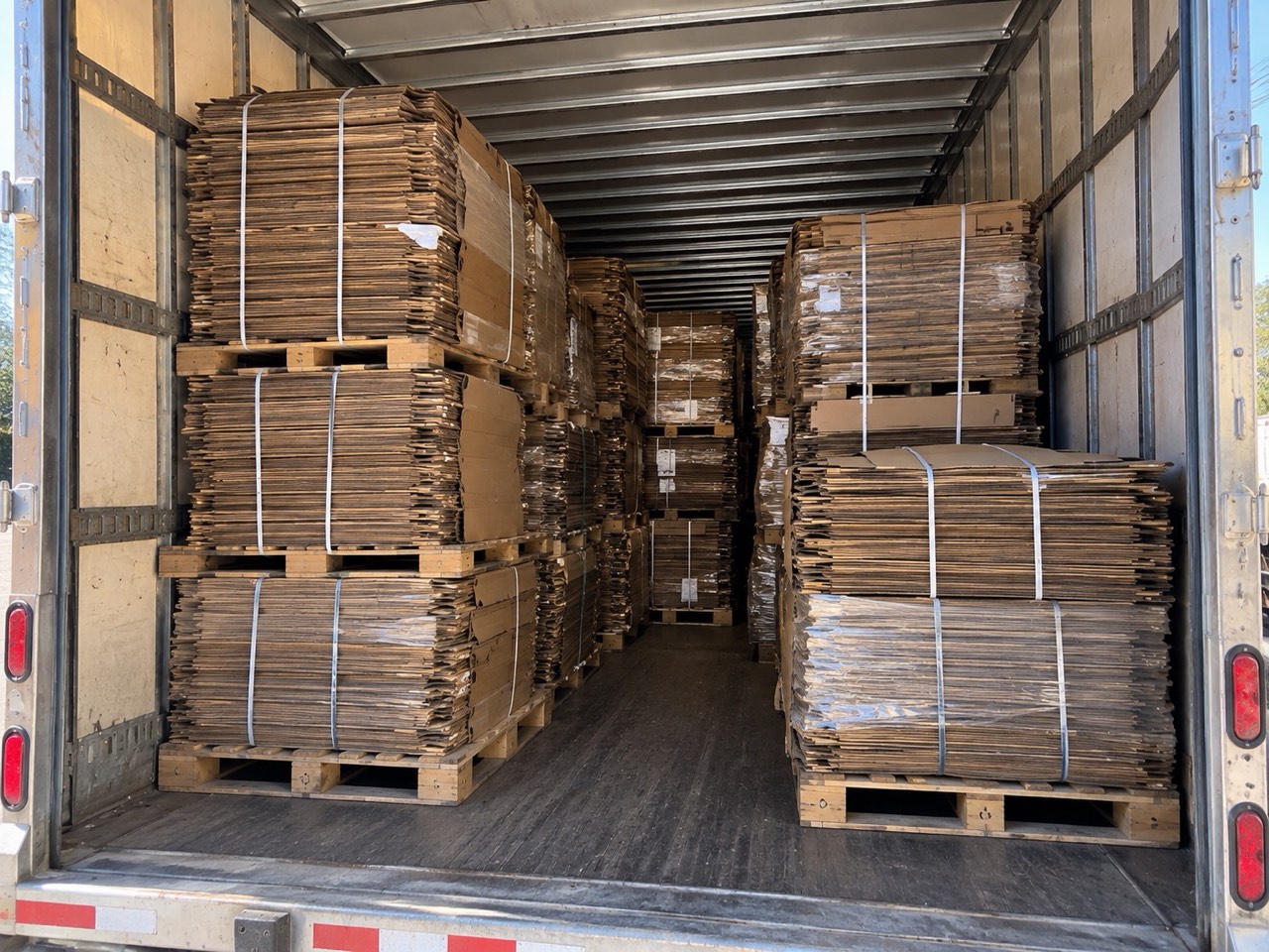 The interior of a loaded 53-foot trailer, double-stacked with pallets of banded flattened bulk boxes